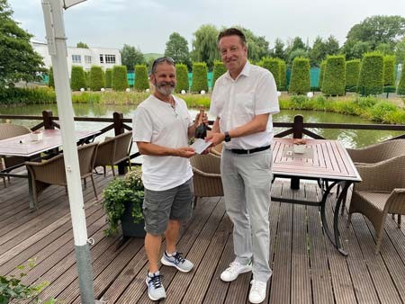  Ralf Weber (rechts, Geschäftsführer OWL Sport & Event GmbH& Co. KG) überreicht Greenkeeper Phil Thorn anlässlich dessen 30-jährigen Firmenjubiläums eine Flasche Bouvet Ladubay. (Foto© OWL Sport & Event/HalleWestfalen)