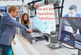 Ein Roboter für die Echtgeldprüfung: Henning Peters, wissenschaftlicher Mitarbeiter vom Fraunhofer IEM, präsentiert den in einem it’s OWL Projekt entstandenen kollaborativen Roboter (Cobot) auf der FMB – Fachmesse für Maschinenbau. Der Cobot soll Diebold Nixdorf beim Echtgeldtest von Geldautomaten und der Montageprüfung von Bedienfeldern an Geldautomaten unterstützen. Foto: it's OWL