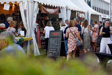 Besucher*innen genießen beim Gourmetmarkt auf dem Kolbeplatz kulinarische Spezialitäten und Live-Musik bei strahlendem Sommerwetter. Foto: Lena Descher