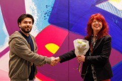 Sayed Aman Sadat aus Afghanistan, der seit vier Jahren in Bielefeld lebt, erhält zum 1.000sten Museumsticket einen Blumenstrauß von Martina Bauer (Atelier Aatifi).Foto: Volker Reinholdt