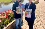 Stephan Berg und Jana Jungblut präsentieren an der Weserpromenade die neuen Printprodukte der Tourist-Information Höxter, die mit frischen Ideen und zielgerichteten Inhalten Lust auf Stadt und die Region machen. Bildquelle: Stadt Höxter