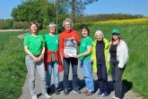 Besonnte und besonnene Fürsprecher:innen des Fuchses: BUND-Aktive beim Treff in Lage-Heßloh mit dem Veranstaltungsplakat, das sowohl in Lemgo als auch in Lage aushängt. Foto: Petra Kuhfus/ BUND Lage.