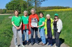 Besonnte und besonnene Fürsprecher:innen des Fuchses: BUND-Aktive beim Treff in Lage-Heßloh mit dem Veranstaltungsplakat, das sowohl in Lemgo als auch in Lage aushängt. Foto: Petra Kuhfus/ BUND Lage.