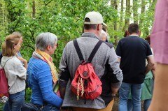 Die Wandergruppe hört gespannt der Wanderführerin Elke Krautscheid zu. Am Rucksack eines Wanderers sieht man die NATUR.PUR-Kette. Foto: pro Wirtschaft GT GmbH