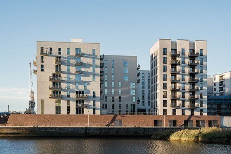 Fotograf: Alex Bach Architekturfotografie // Nutzungsrecht: Schüco International KG Der filigrane Wohnturm mit seiner klar gegliederten Fassade, den vertikalen Einschnitten für Balkone und der markanten Krone mit Dachgarten setzt einen markanten Akzent im Stadtbild.