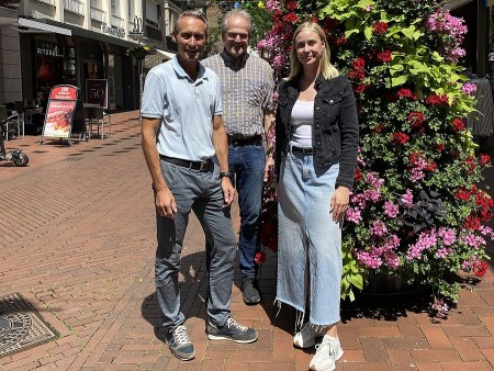 Gemeinsam für mehr Grün in der Innenstadt: Peter Oesterhelweg (l.) und Christoph Fritzenkötter, beide aus dem Vorstand der ISG Mittlere Berliner Straße, und Clara Abelmann (Gütersloh Marketing) präsentieren die neuen Pflanzen-Pyramiden. Foto: Gütersloh Marketing