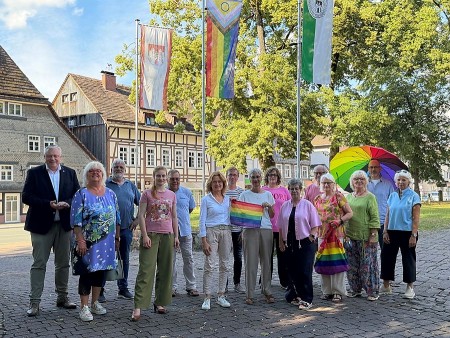 Bürgermeister Daniel Hartmann und Vertreterinnen und Vertreter des Bündnisses für Demokratie und Vielfalt vor der Regenbogenfahne am Stadthaus. Bildquelle: Stadt Höxter