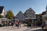 Besucherinnen und Besucher zwischen Marktständen auf dem Bürener Marktplatz bei sonnigem Wetter