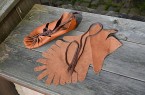 Römische Bundschuhe und zugeschnittene Lederteile auf einer Holzbank