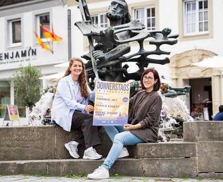 Lena Schräder vom Citymanagement Paderborn und Marie Junker von B&S präsentieren das Veranstaltungsplakat für „Donnerstags in Paderborn“. Foto/Copyright: Citymanagement Paderborn