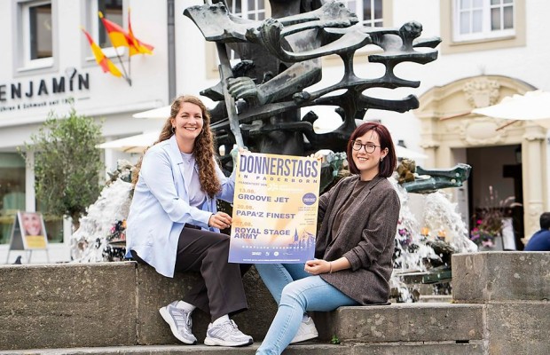 Lena Schräder vom Citymanagement Paderborn und Marie Junker von B&S präsentieren das Veranstaltungsplakat für „Donnerstags in Paderborn“. Foto/Copyright: Citymanagement Paderborn
