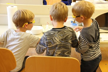 Drei Kinder mit Schutzbrillen bei einem Goldexperiment im Museumslabor. Foto: © Weserrenaissance-Museum Schloss Brake
