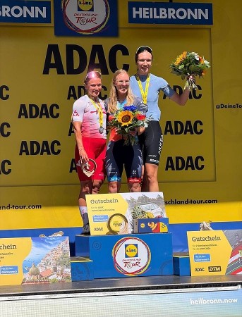 Drei Radsportlerinnen stehen bei der Siegerehrung der ADAC Cycling Tour 2026 auf dem Podium in Heilbronn.
