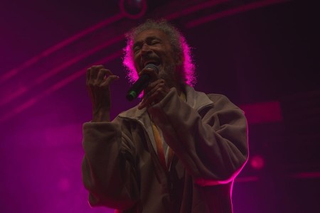 Sänger und Festivalhost Andrew Murphy mit Mikrofon im pinkfarbenen Bühnenlicht.