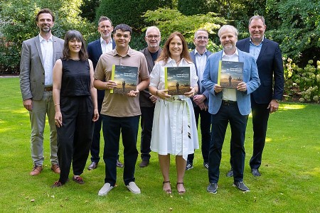 Gruppenfoto bei der Vorstellung des CLAAS Buches „Innovationen für Generationen“; drei Personen halten Exemplare in den Händen.