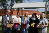 Fünf Personen präsentieren vor dem Kloster Dalheim verschiedene Klosterprodukte, darunter Bier, Handarbeiten, Marmelade und einen Geschenkkorb.