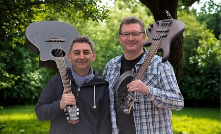 Daniel Farrokh und Manfred Olke von Danni & Manni mit Gitarren vor Bäumen im Grünen