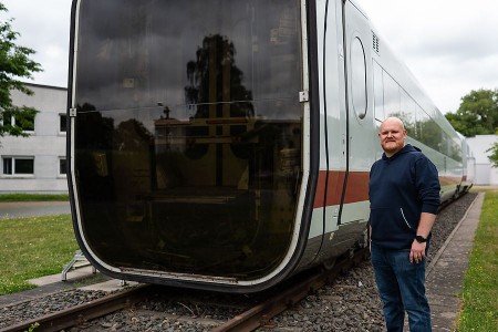 Student Johannes Reinholz steht neben einem ausrangierten ICE auf dem RailCampus OWL in Minden.