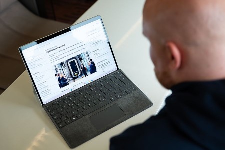 Johannes Reinholz betrachtet auf einem Laptop die Webseite des Bachelorstudiengangs Digitale Bahnsysteme.