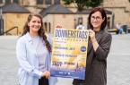 Zwei Frauen halten auf dem Paderborner Domplatz ein Plakat für „Donnerstags in Paderborn“.
