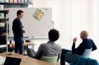 Drei Männer besprechen vor einem Whiteboard Schnittmuster und Servietten bei Duni.