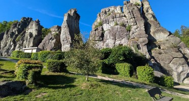 Externsteine bei Horn-Bad Meinberg mit markanten Felsformationen, Grünflächen und Sitzbank unter blauem Himmel
