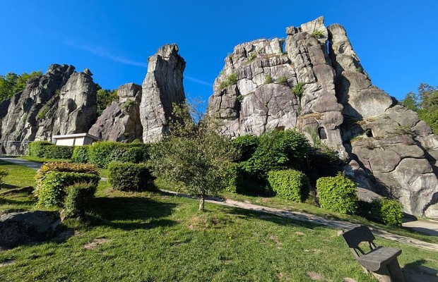 Externsteine bei Horn-Bad Meinberg mit markanten Felsformationen, Grünflächen und Sitzbank unter blauem Himmel