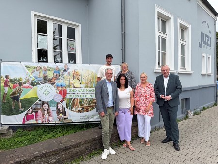 Sechs Beteiligte am Ferienprogramm in Höxter stehen vor dem Juzi Höxter neben einem Banner der FerienZEIT.