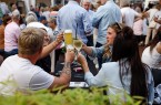 Besucherinnen und Besucher stoßen beim Gourmetmarkt auf dem Kolbeplatz mit Bier und Wein an.