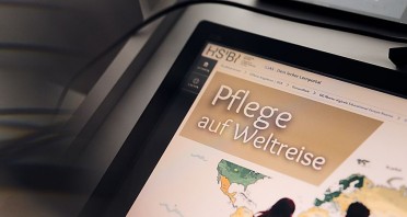 Tablet mit dem HSBI-Lernportal und der Anzeige „Pflege auf Weltreise“ für einen digitalen Educational Escape Room.