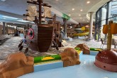 Kinderbereich im Ishara mit großem Spielschiff, Planschbecken und gelber Rutsche im Hintergrund.