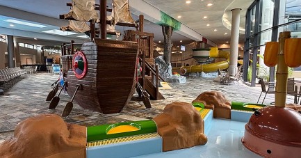 Kinderbereich im Ishara mit großem Spielschiff, Planschbecken und gelber Rutsche im Hintergrund.