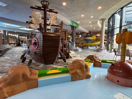 Kinderbereich im Ishara mit großem Spielschiff, Planschbecken und gelber Rutsche im Hintergrund.