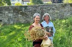 Zwei Frauen im Abteigarten Marienmünster, eine mit einem Krautbund und die andere mit einem Buch.