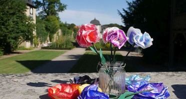Bunte Papierblumen in einer Glasvase vor dem Klostergarten des Klosters Dalheim