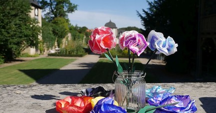Bunte Papierblumen in einer Glasvase vor dem Klostergarten des Klosters Dalheim