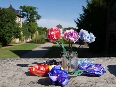 Bunte Papierblumen in einer Glasvase vor dem Klostergarten des Klosters Dalheim