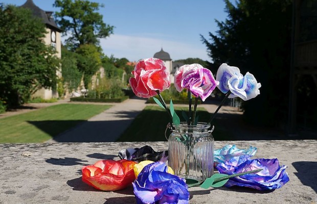 Bunte Papierblumen in einer Glasvase vor dem Klostergarten des Klosters Dalheim