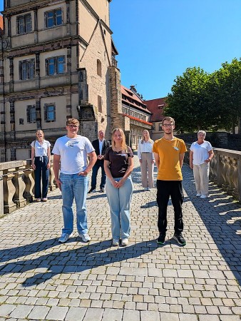 Drei neue Auszubildende beim Landesverband Lippe mit vier Mitarbeitenden vor Schloss Brake.