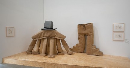Installation mit vergrößertem braunem Kostüm, schwarzem Hut und großer Hose in der Ausstellung im Marta Herford.
