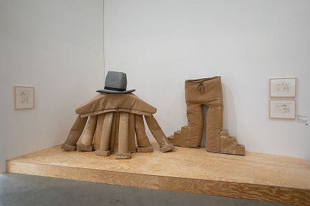 Installation mit vergrößertem braunem Kostüm, schwarzem Hut und großer Hose in der Ausstellung im Marta Herford.