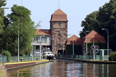 Historische Schachtschleuse Minden mit Schleusenkanal, Backsteinturm und einem Boot