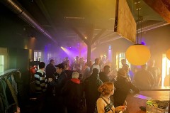 Gäste bei der Paradance im Weberei-Bahnhof unter farbigem Licht.