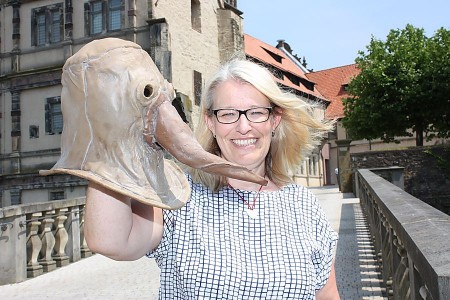 Dr. Susanne Hilker zeigt eine Pestmaske, die in der Zeit der Weserrenaissance vor Krankheiten schützen sollte. © Foto: Weserrenaissance-Museum Schloss Brake/Herrmann