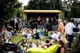 Band auf der Bühne beim Picknick-Konzert an der Krullsbachaue vor sitzendem Publikum © Matheus Fernandes