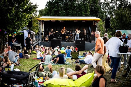 Band auf der Bühne beim Picknick-Konzert an der Krullsbachaue vor sitzendem Publikum © Matheus Fernandes
