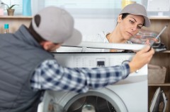 Servicetechniker und Kundin prüfen gemeinsam eine geöffnete Waschmaschine während einer Reparatur.
© Foto: Verbraucherzentrale NRW
