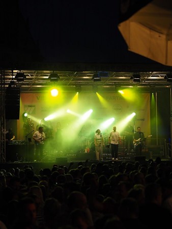 Posaunist der Royal Stage Army spielt auf der beleuchteten Bühne beim Finale auf dem Domplatz.