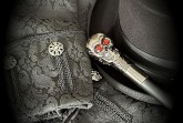Schwarzer Zylinder, gemusterte schwarze Kleidung und ein Gehstock mit Totenkopfgriff.
