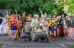 Das Ensemble von „Shrek – Das Musical“ posiert in Märchen- und Tierkostümen vor einer grünen Waldkulisse.
